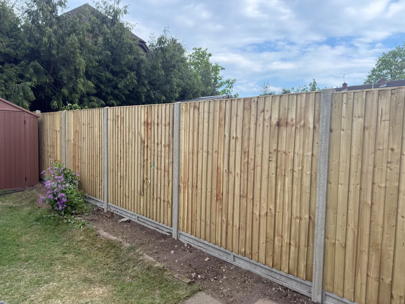 Long run of closeboard fence panels and gravel boards in a Surrey garden