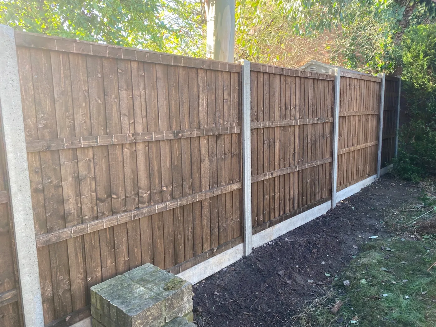 Brown closeboard fence panels fitted with concrete posts and gravel boards in Surrey