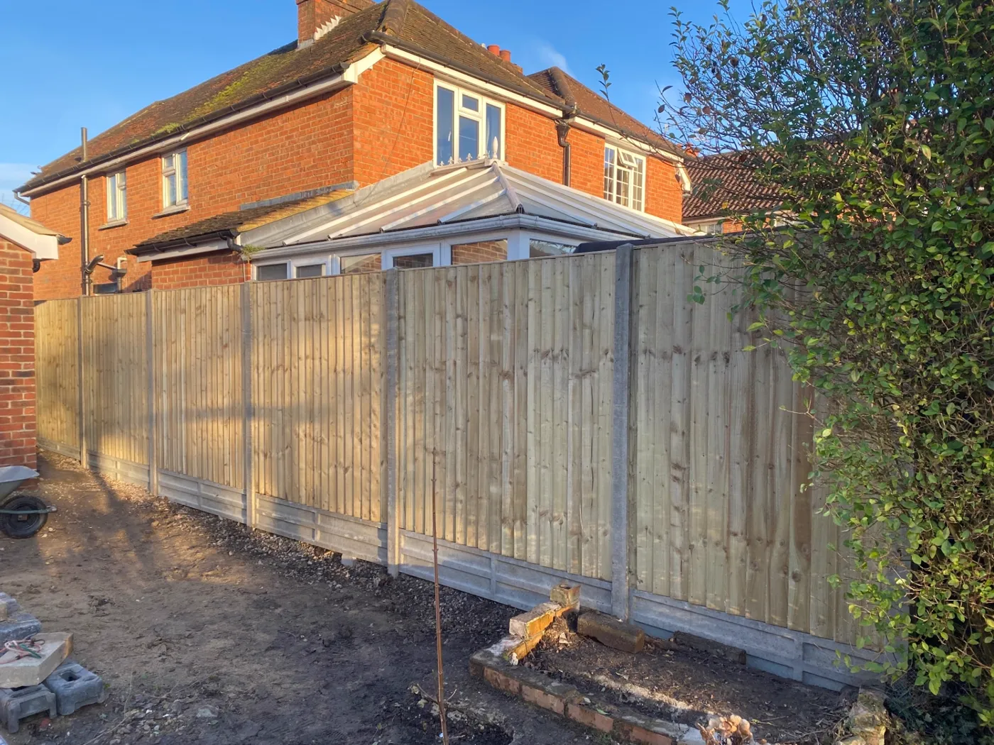 New closeboard garden fence with concrete posts and gravel boards in a Surrey garden